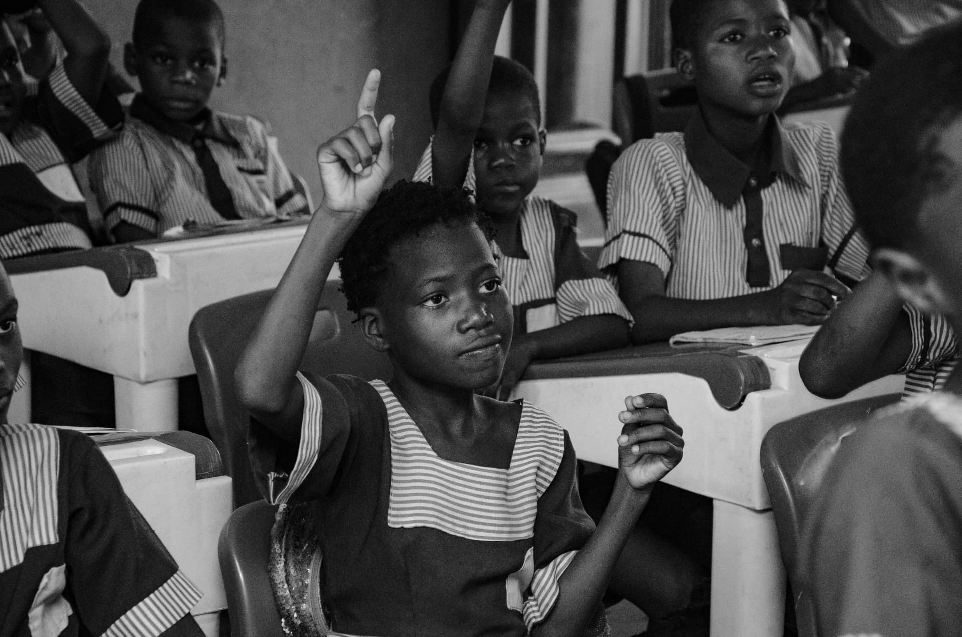 Students raising hands in class